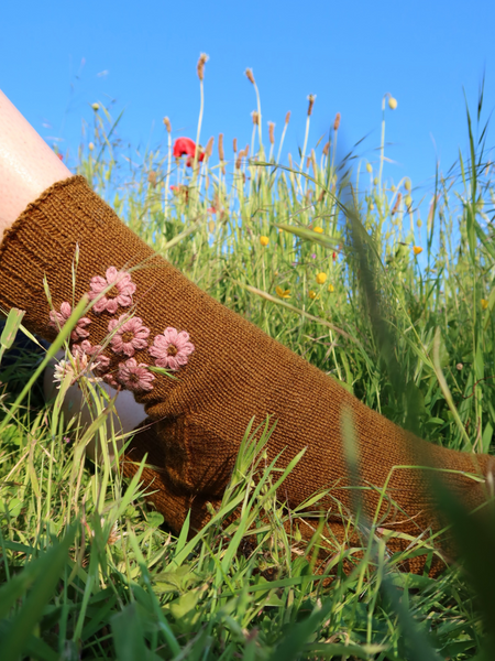 Close up of Blathan hand knitted Socks in a khaki green with pink embroidered flowers 