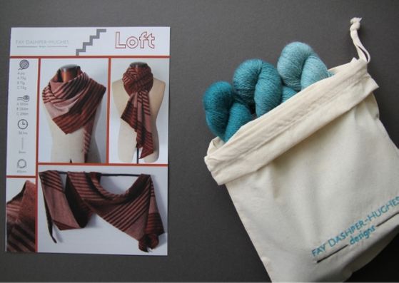 Knit kit for Loft shawl: on left is a hardcopy of the pattern showing the shawl off in three shades of copper and on the right are the three shades of teal available getting darker from right to left, all sat in a rolled back bag with "Fay Dashper-Hughes Designs" embroidered on it.