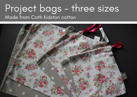 Six project bags lying on top of each other in a fan.  They range from large to medium, to small from left to right and alternate from a beige colour with white dots and a cream colour with a pink and green floral pattern.
