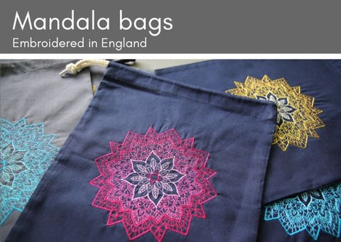 Embroidered mandala project bags:  three navy bags on top of a grey one.  Each has a machine embroidered mandala on it in various colurs (pink, yellow or turquoise).  The mandalas change shade going from a darker outer to a lighter inner.