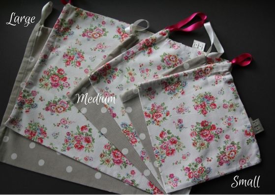 Six project bags lying on top of each other in a fan.  They range from large to medium, to small from left to right and alternate from a beige colour with white dots and a cream colour with a pink and green floral pattern.