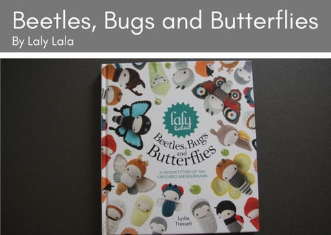 Beetles, Bugs and Butterflies by Laly Lala lies on a grey background.  The front cover is white with crcoheted bugs, beetles and butterflies all over it.