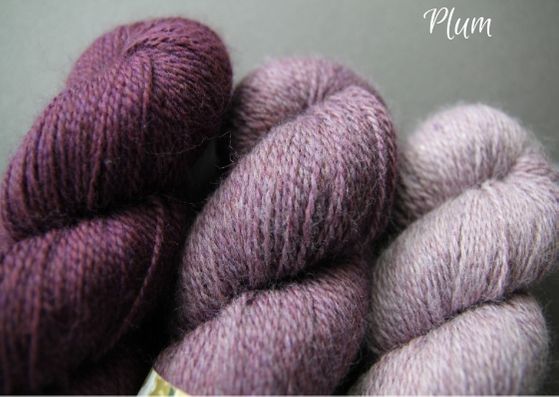 Skeins showing three shades of plum John Arbon Textiles merino 4 ply wool available getting darker from right to left.
