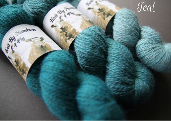 Skeins showing three shades of teal John Arbon Textiles merino 4 ply wool available getting darker from right to left.